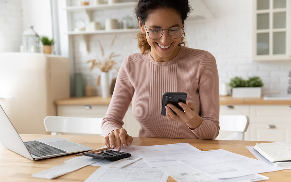 Woman holding phone sitting at a table