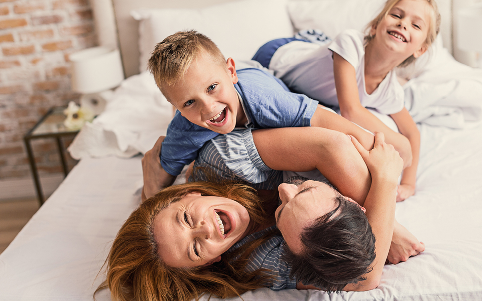 Family rolling on bed